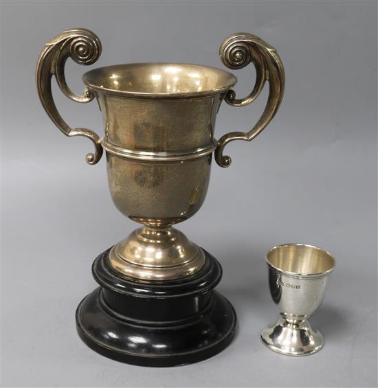 A George V silver trophy cup by Walker & Hall and a silver egg cup.